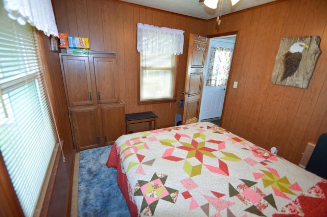 bedroom featuring multiple windows and wooden walls