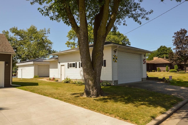 exterior space featuring a garage, a front lawn, and an outdoor structure