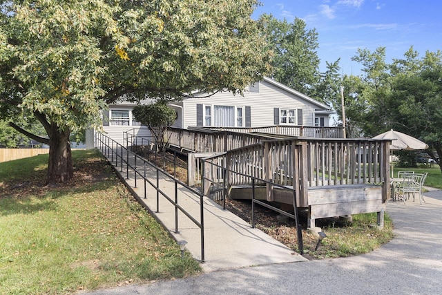 view of front of home with a deck and a front yard