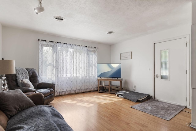 living room featuring a textured ceiling and light hardwood / wood-style floors