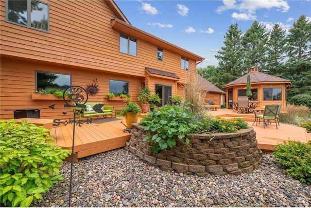 back of property featuring a wooden deck and a gazebo