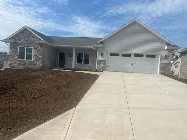 view of front of home featuring a garage, stone siding, and concrete driveway