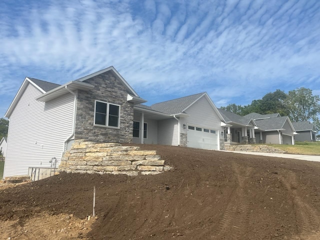 view of front of house with an attached garage, stone siding, and concrete driveway