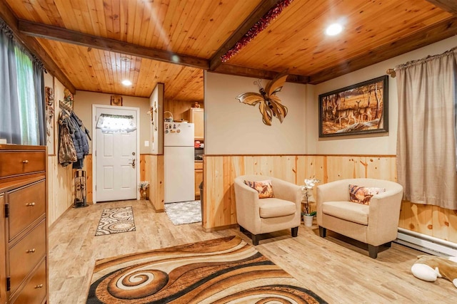 living area featuring a wainscoted wall, a baseboard heating unit, wood ceiling, beam ceiling, and light wood finished floors