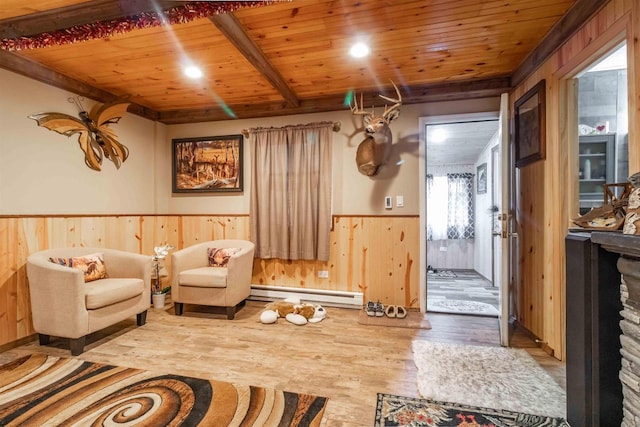 sitting room with a baseboard heating unit, a wainscoted wall, wood walls, wood finished floors, and wood ceiling