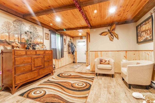 living area with wooden ceiling, a wainscoted wall, and beamed ceiling