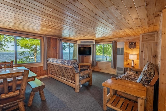 bedroom with wooden ceiling, a water view, dark carpet, and wooden walls