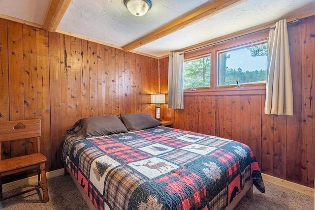 carpeted bedroom featuring wood walls and beam ceiling