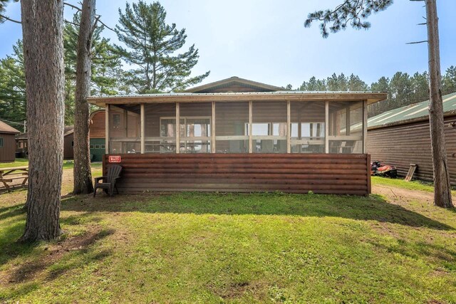 back of house with a sunroom and a yard