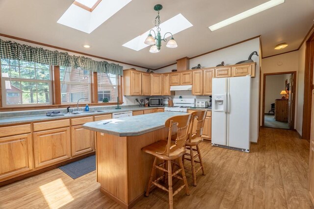 kitchen featuring light wood-type flooring, a center island, lofted ceiling with skylight, and white appliances