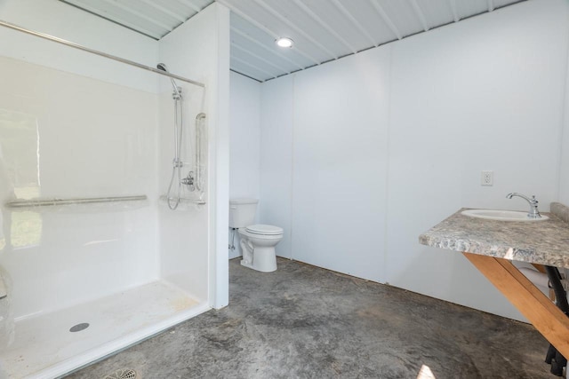 bathroom featuring toilet, a shower stall, concrete flooring, and a sink