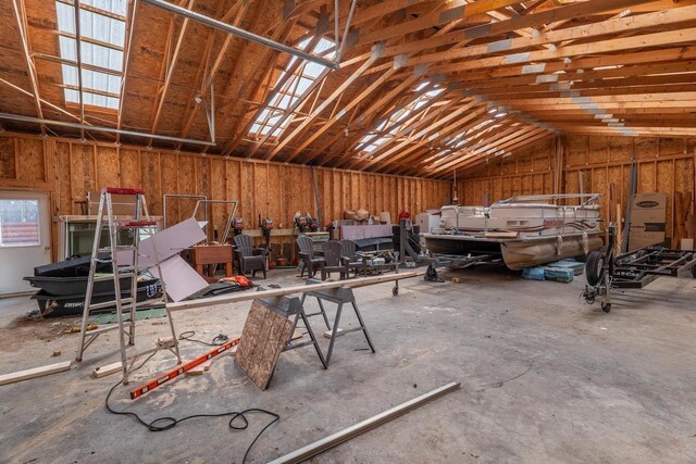 misc room with vaulted ceiling and concrete flooring