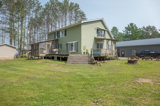 back of house with a deck and a yard