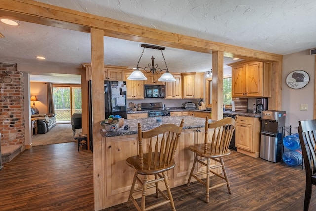 kitchen with dark colored carpet, a breakfast bar area, hanging light fixtures, a textured ceiling, and black appliances