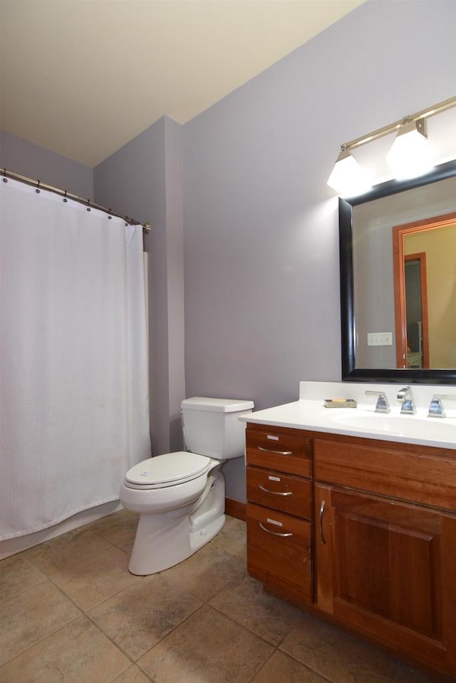 bathroom featuring tile patterned flooring, toilet, and vanity