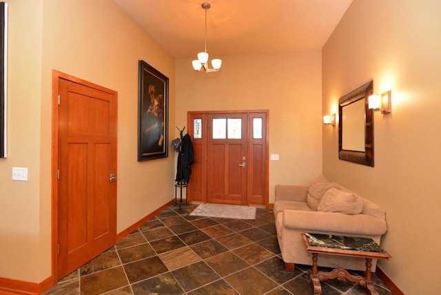 foyer entrance with dark tile patterned floors and a chandelier