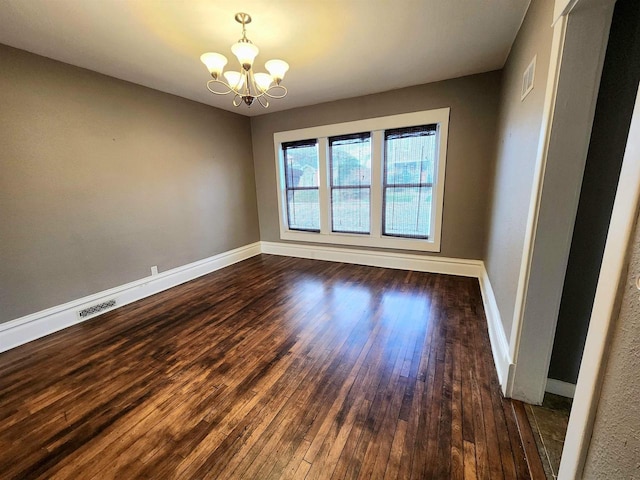 empty room featuring an inviting chandelier, baseboards, visible vents, and dark wood-style flooring