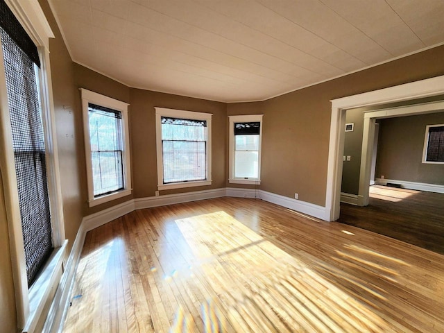 empty room with baseboards and hardwood / wood-style floors