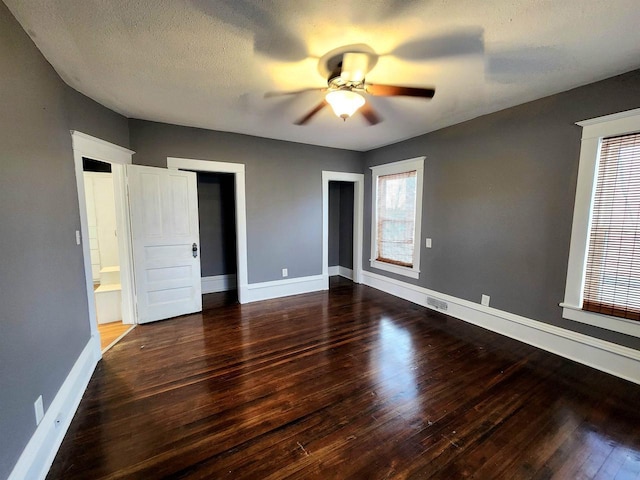 unfurnished bedroom featuring a textured ceiling, a ceiling fan, baseboards, and wood finished floors