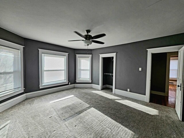 unfurnished bedroom with a ceiling fan, baseboards, and carpet floors