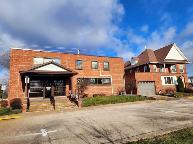 townhome / multi-family property featuring brick siding and a garage