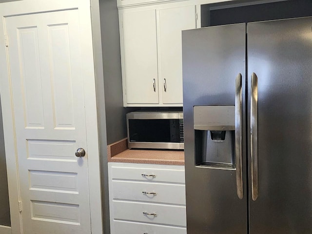 kitchen with light countertops, white cabinets, and stainless steel appliances