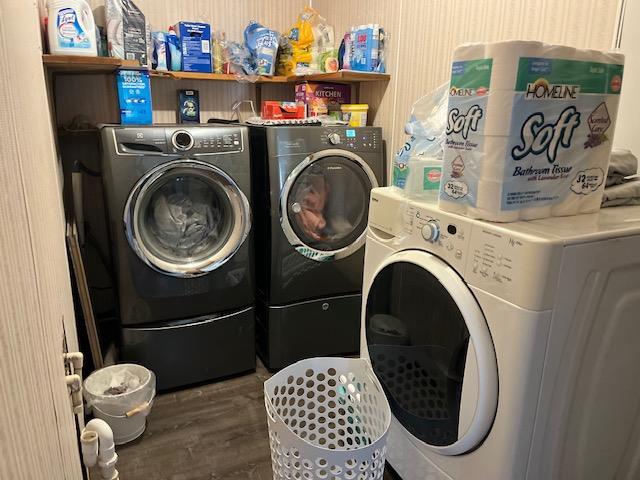 laundry room with dark hardwood / wood-style floors and washing machine and clothes dryer