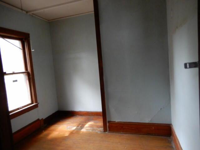 empty room featuring plenty of natural light, light wood-style flooring, and baseboards