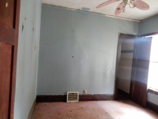 unfurnished room with visible vents, ceiling fan, and baseboards