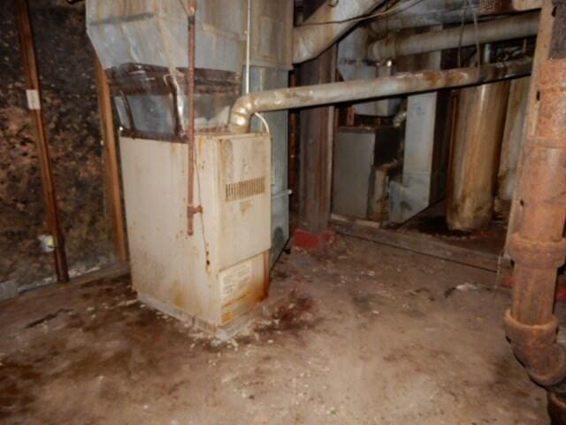 unfinished basement featuring heating unit