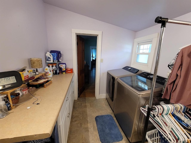 laundry area featuring independent washer and dryer, light tile patterned floors, and cabinets