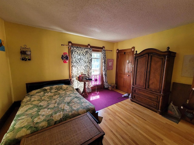 bedroom featuring a textured ceiling and light hardwood / wood-style floors