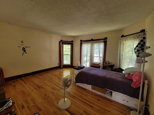 bedroom featuring a textured ceiling and hardwood / wood-style flooring