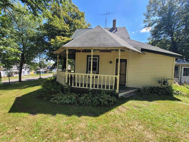 rear view of property featuring a lawn