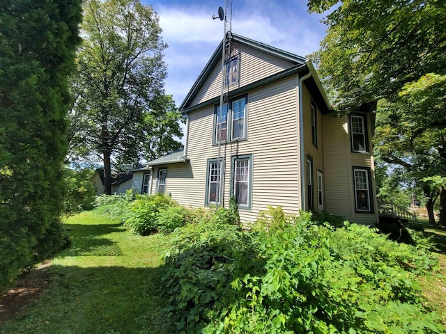 view of side of home with a yard