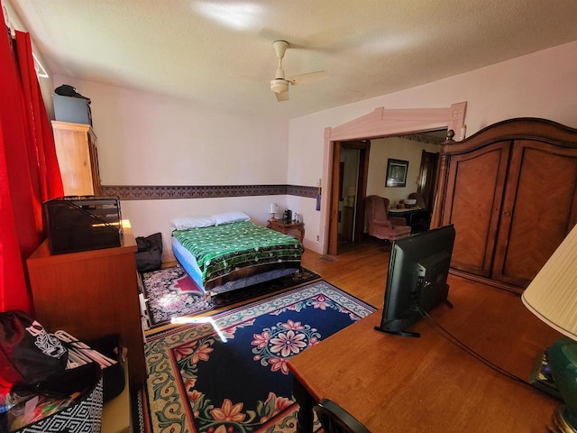 bedroom featuring a textured ceiling, ceiling fan, and hardwood / wood-style flooring