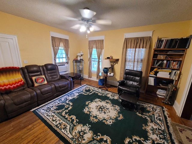 living room with hardwood / wood-style floors, cooling unit, a textured ceiling, and ceiling fan