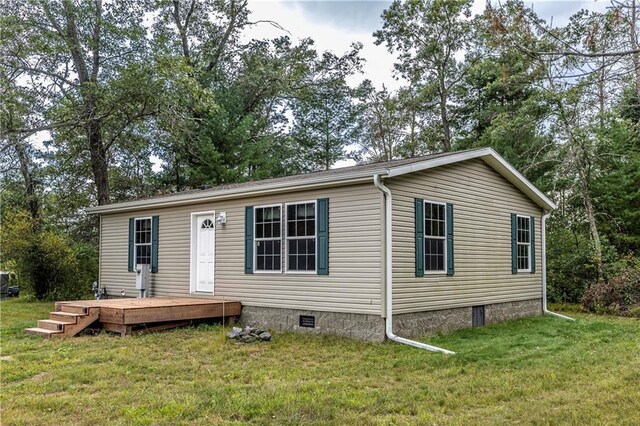 manufactured / mobile home featuring a deck and a front lawn