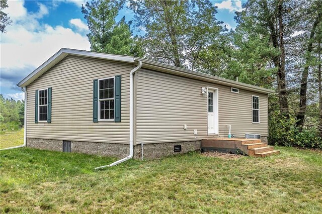 back of property with a yard and a wooden deck