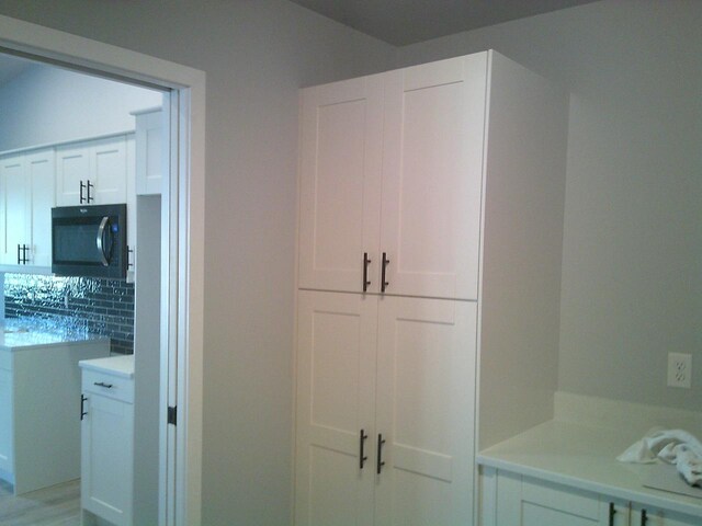 interior space featuring white cabinetry and tasteful backsplash