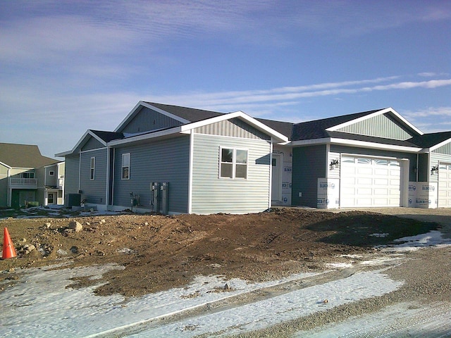 ranch-style home featuring board and batten siding, driveway, and an attached garage