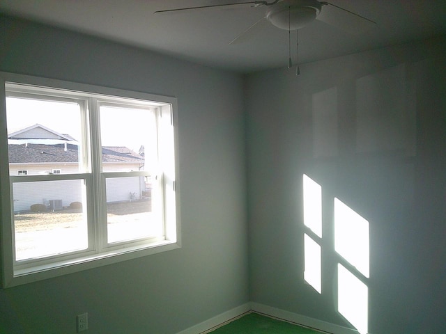 spare room featuring a ceiling fan and baseboards