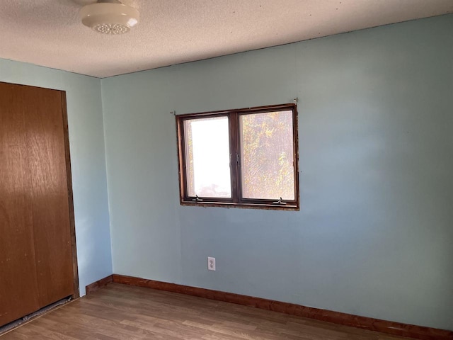 N9185 9th Ave, New Lisbon, WI 53950 - empty room featuring wood finished floors, baseboards, and a textured ceiling