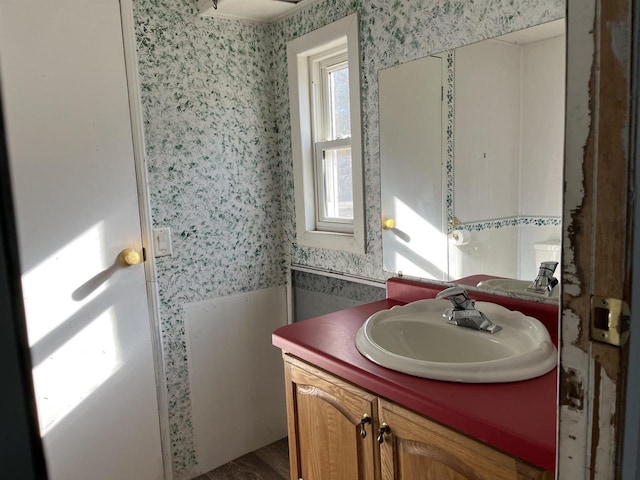 N9185 9th Ave, New Lisbon, WI 53950 - bathroom featuring wallpapered walls, vanity, and wood finished floors