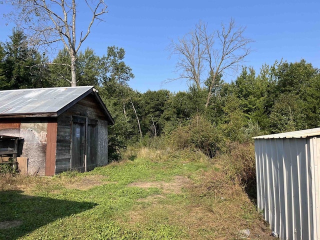 N9185 9th Ave, New Lisbon, WI 53950 - view of yard featuring a shed, an outbuilding, and a wooded view