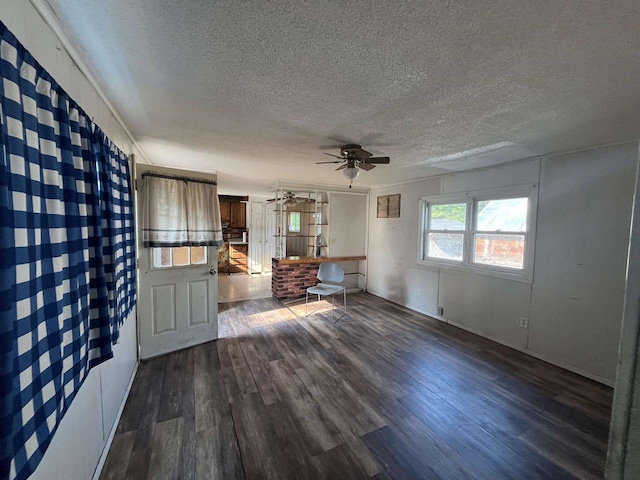 N9185 9th Ave, New Lisbon, WI 53950 - unfurnished living room featuring a textured ceiling, a ceiling fan, and dark wood finished floors