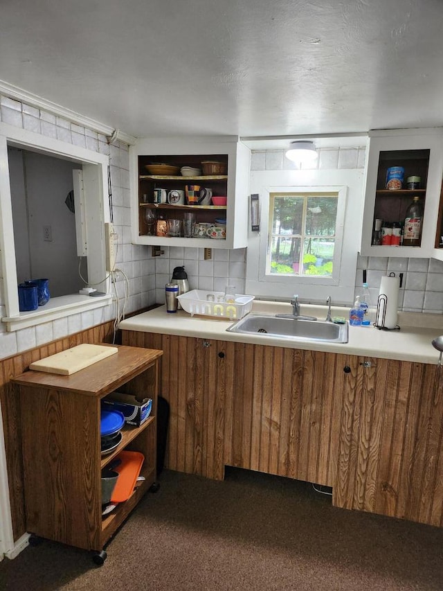 kitchen with sink, tile walls, and dark colored carpet