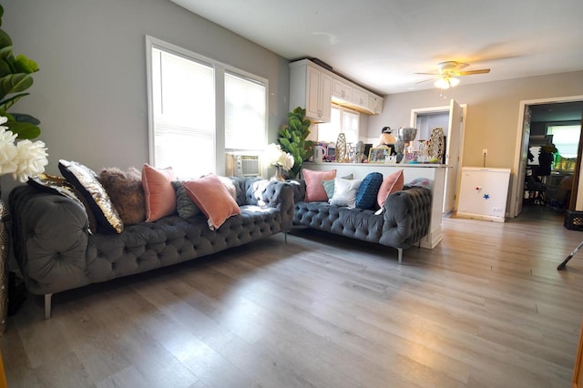 living room with light hardwood / wood-style flooring and ceiling fan