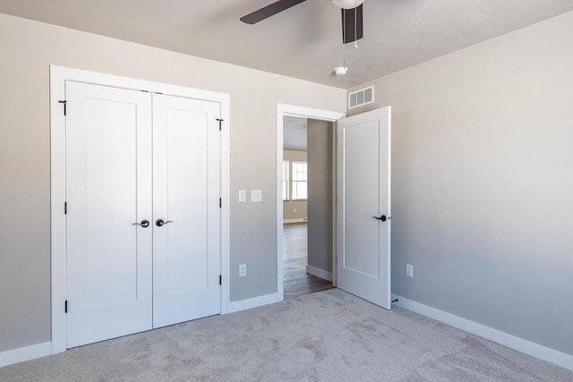 unfurnished bedroom with light carpet, a ceiling fan, visible vents, baseboards, and a closet