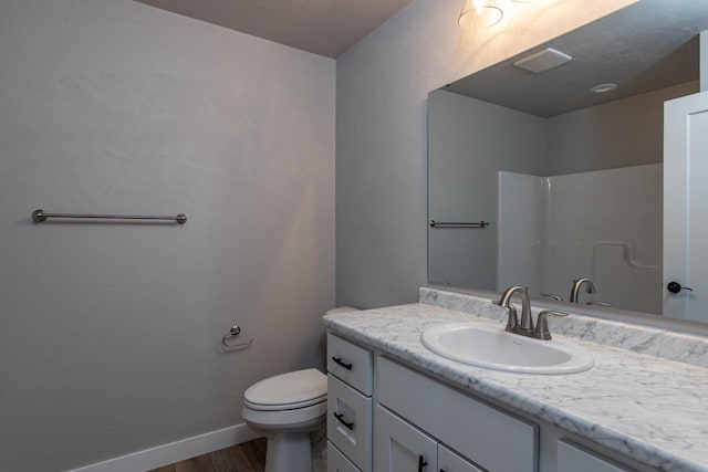 full bathroom featuring toilet, wood finished floors, vanity, baseboards, and a shower